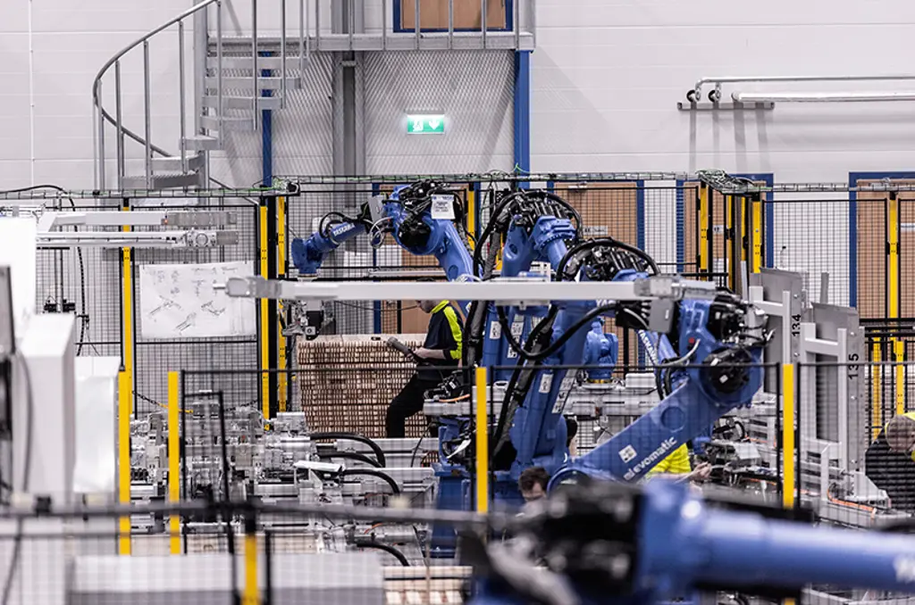 Robotarmen die kartonnen dozen palletiseren in een beveiligde automatiseringscel