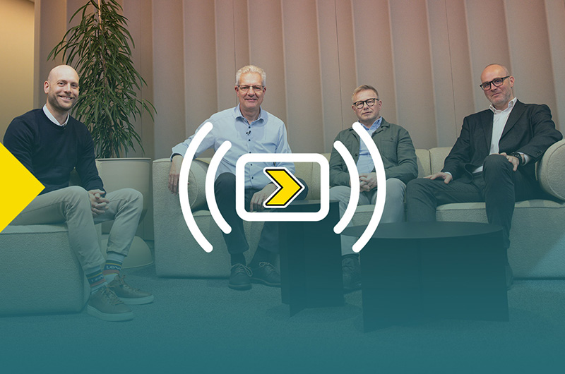 Vier mannen zitten op banken met hun gezicht naar de camera. Het beeld heeft een kleurovergang met het logo van Axelents webinar “Axelent Goes Live”.