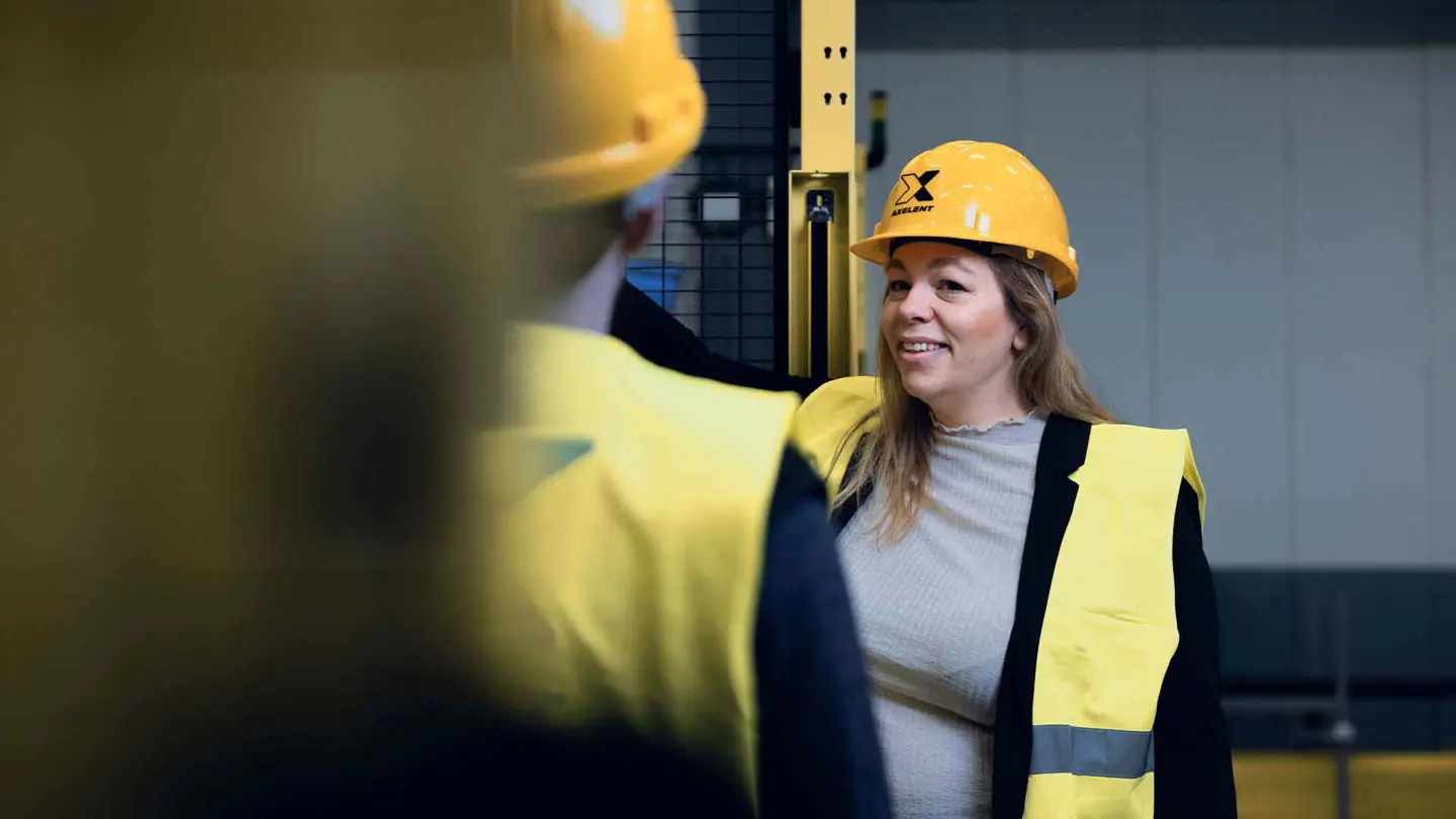 Een vrouw praat en laat zien hoe je een industriële machine bedient