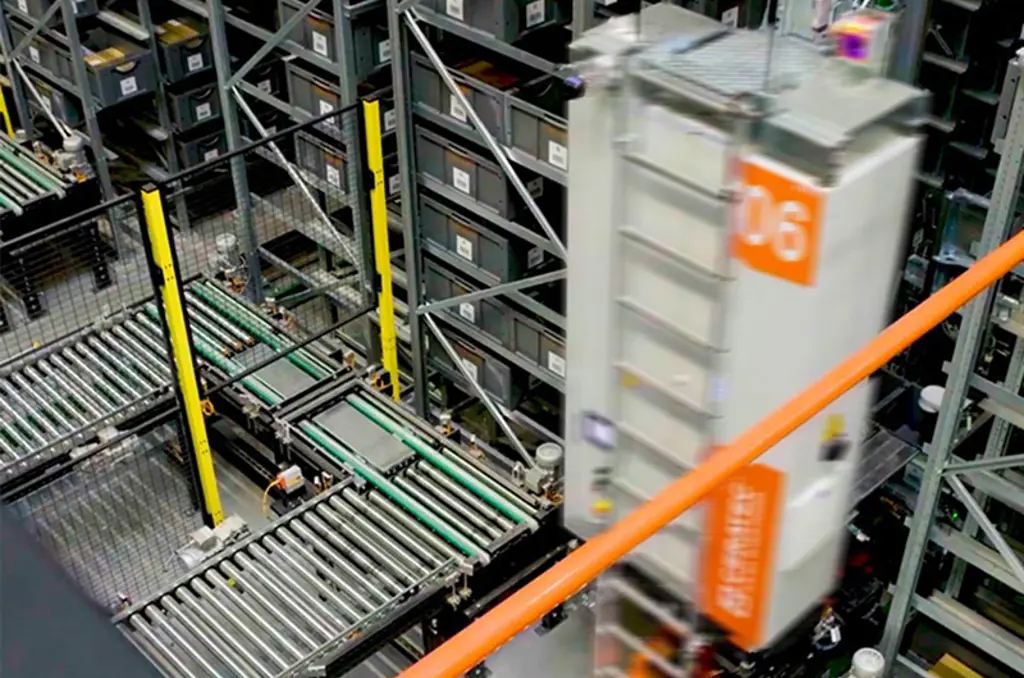 Geautomatiseerd magazijn met transportbanden en een snelle opslagrobot tussen hoge rekken met bakken