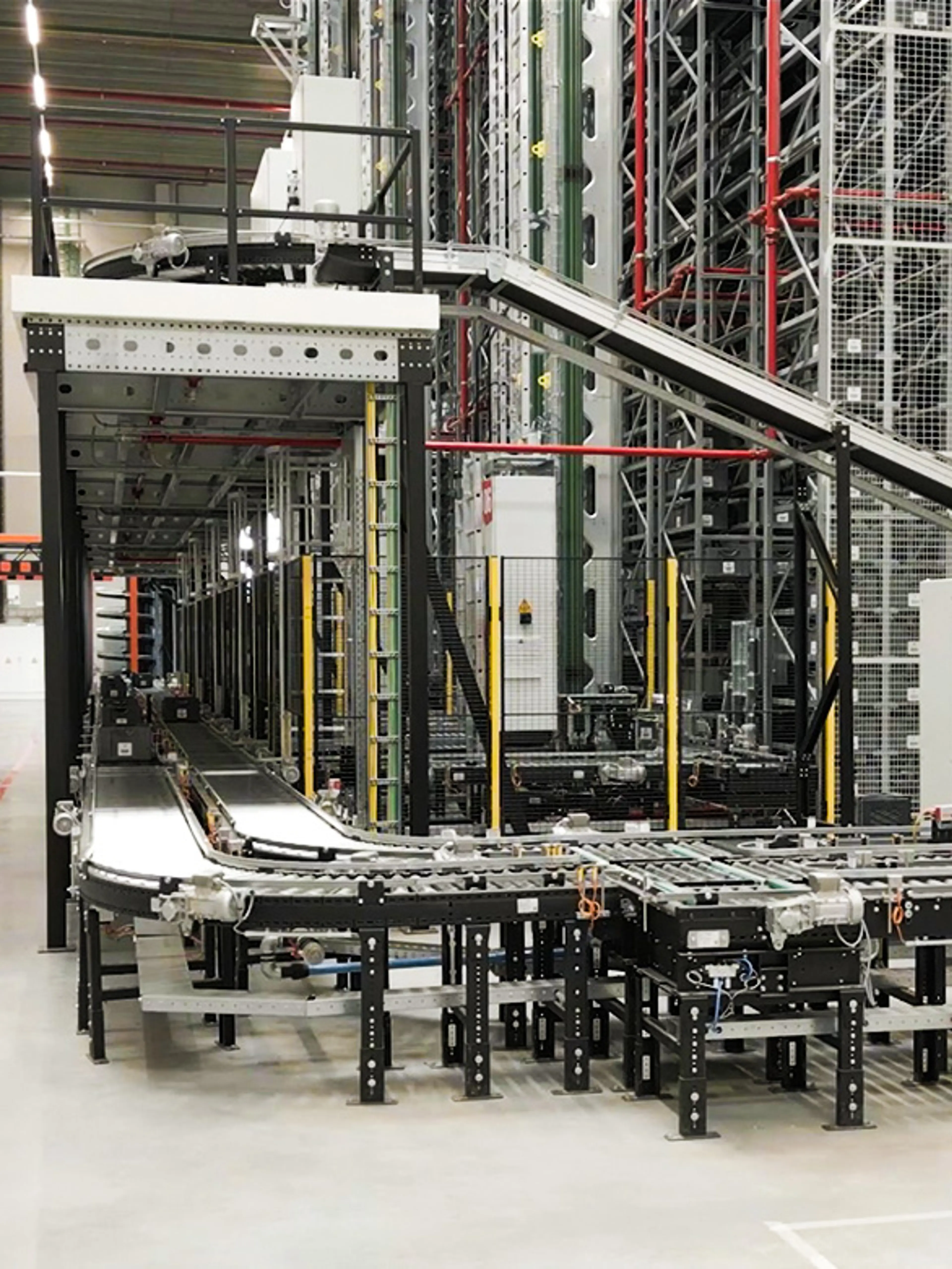 Geautomatiseerd rollen- en transportbandsysteem in een magazijn, gebruikt voor het vervoeren van bakken en containers