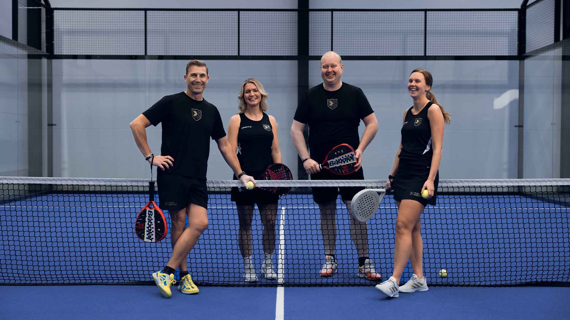 Blue court in Axelents padel center with four people standing together