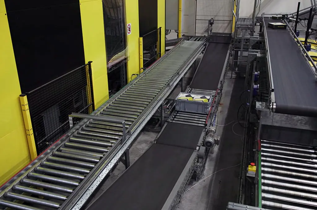 Geautomatiseerd sorteersysteem voor magazijnen met transportbanden en veiligheidshekken voor snelle logistiek